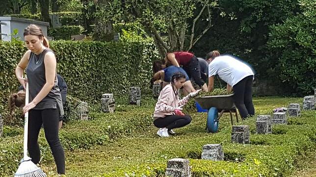 Teilnehmer des Workcamps pflegen die Anlage auf dem Friedhof. Bild: Markus Porm