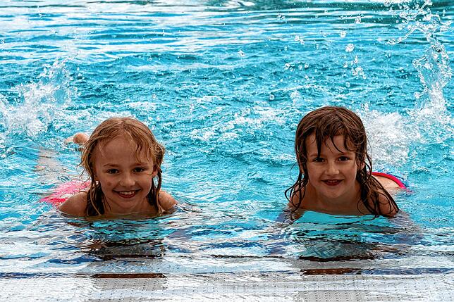 Johanna Bauer (8 Jahre) (links) mit ihrer Schwester Juliana (5) freuen sich, endlich wieder im Wasser nach Herzenslust planschen zu können.