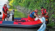 Die Feuerwehr Bad Säckingen bringt eine Ölsperre aus.