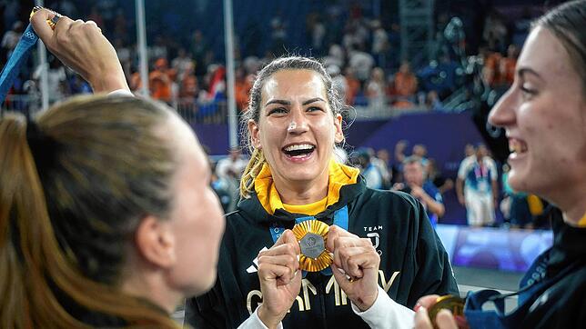 Sonja Greinacher feiert mit dem Team den Gewinn der Goldmedaille.