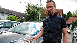 Mit solchen Steinen – wie hier Geschäftsführer Steffen Albert zeigt – wird nachts auf die Autos auf der Ausstellungsfläche des ...