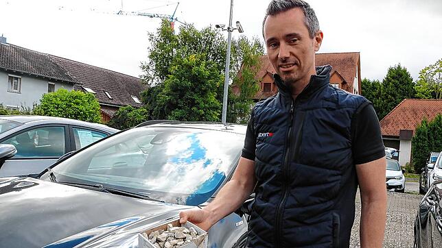 Mit solchen Steinen – wie hier Geschäftsführer Steffen Albert zeigt – wird nachts auf die Autos auf der Ausstellungsfläche des ...