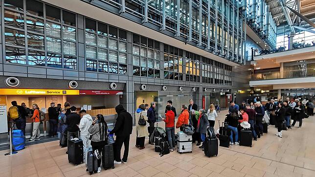 Reisende warten in Hamburg an einem Serviceschalter der Lufthansa. Eine IT-Panne sorgt für große Behinderungen