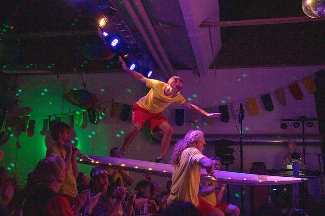 Baywatch lässt grüßen: Rettungsschwimmer Florian Amrein surft, getragen von seinen Zunftratskollegen, durchs Publikum.