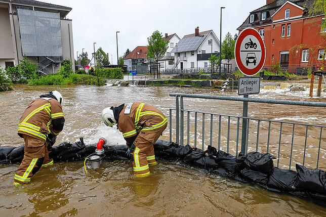 Einsatzkräfte der Feuerwehr stapeln in Ochsenhausen Sandsäcke als Schutzwall auf. Der Fluss Rottum ist über die Ufer getreten, Teile der ...