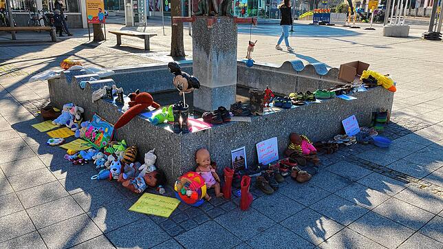 Spielzeug und Schuhe, aber auch Notizzettel mit Verschwörungstheorien, finden sich am Narrenbrunnen in Rheinfelden.