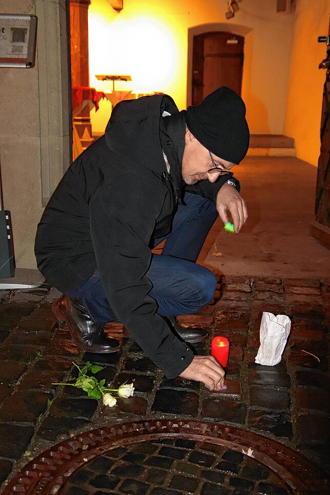 Konstanz&lsquo; Oberbürgermeister Uli Burchardt putzt am Donnerstagabend den Stolperstein vor dem Rathaus.