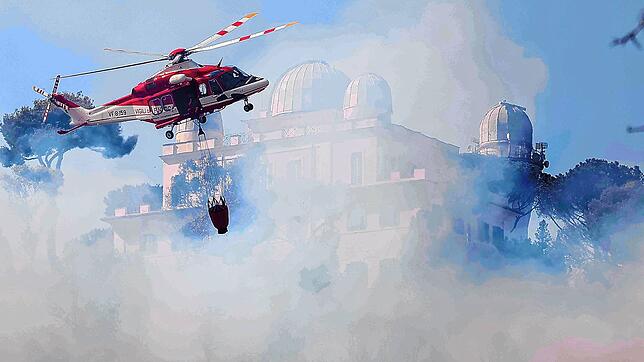 Ein Löschhubschrauber versucht das Feuer in der Nähe des Gerichtsgebäudes in der Gegend von Monte Mario zu löschen.