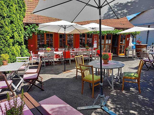 Lauschiges Plätzchen unter Sonnenschirmen und Baumkronen: Im Innenhof lässt es sich auch an sommerlichen Hitzetagen angenehm aushalten.