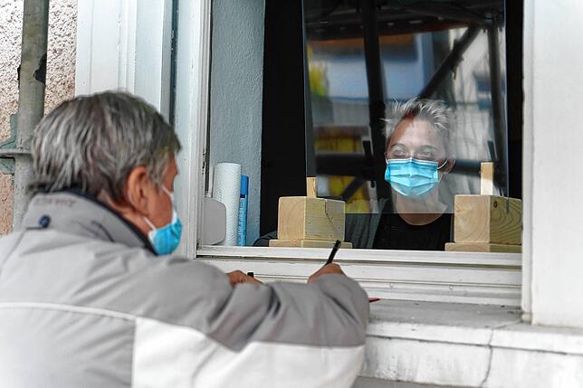 Die Wohnungslosen &ndash; wie hier Dieter Rattke &ndash; werden von Sozialarbeiterin ... durch ein Fenster beraten.