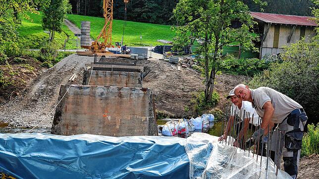 Carmelo Vicino (links) und Ivica Krijan sichern den frisch gegeossenen Beton an der Wutachbrücke in Achdorf vor dem nahenden Regen.