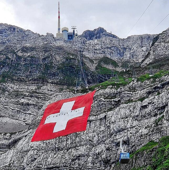 Die Schweizer Fahne am Säntis: Auf der Flagge sind die Kletterer zu erkennen, die sie entrollen.