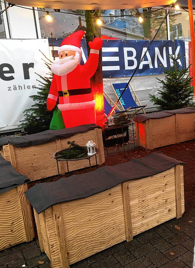 Das Zelt mit Beleuchtung, Sitzmöglichkeiten und einem Nikolaus im Hintergrund bietet auch bei Regen einen gemütlichen Platz.