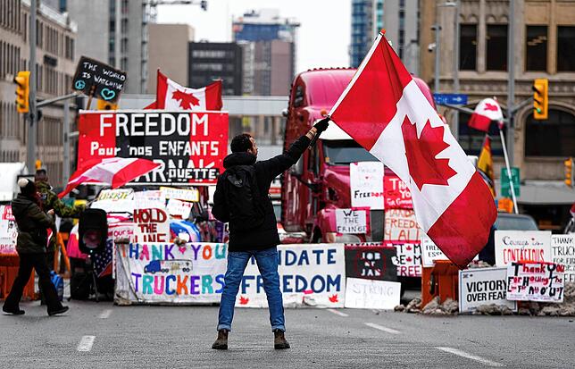 Ein Demonstrant schwenkt bei einem Protest gegen die Corona-Maßnahmen in Ottawa eine kanadische Flagge. Premier Justin Trudeau schließt ...