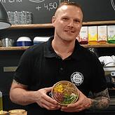 &bdquo;Sieht aus wie Plastik, ist aber kompostierbar.&ldquo; Fabian Sihler von Black Forest Burger mit einer Salatschüssel aus PLA-Plastik.