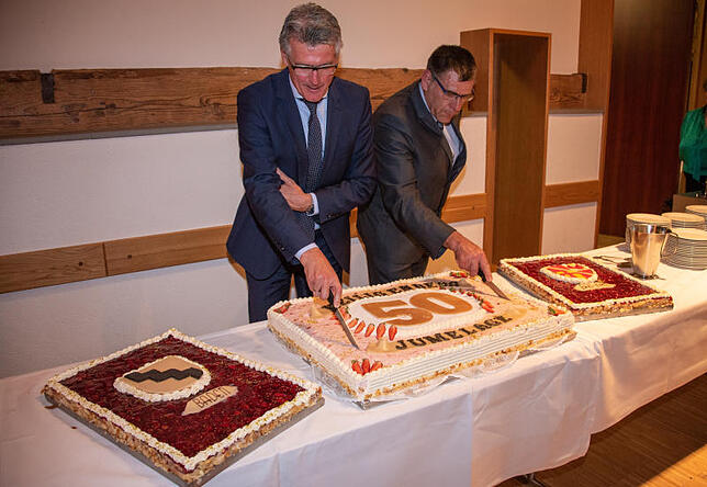 Gemeinsam schnitten Bürgermeister Frank Amann (links) und Guy Ernst die Jubiläumstorte der Gemeindepartnerschaft an.