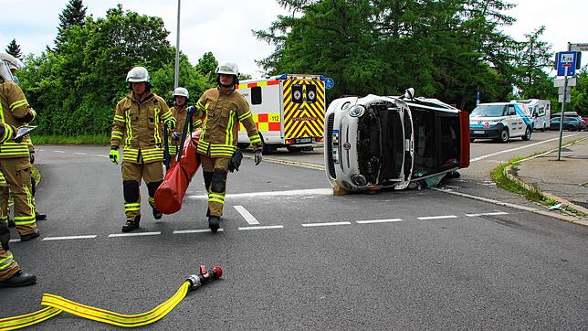 Feuerwehrleute beseitigen aus dem Unfallauto ausgetretenen Treibstoff.