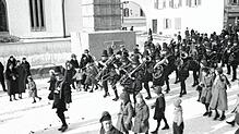 Bei einer Fasnacht in den 1930er-Jahren lag Schnee. Der Umzug geht am Kriegerdenkmal vorbei.
