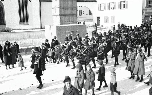 Bei einer Fasnacht in den 1930er-Jahren lag Schnee. Der Umzug geht am Kriegerdenkmal vorbei.