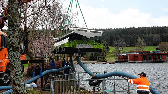Die Zirkulationsanlage schwebt über dem Klosterweiher. Sie wird dort, wo der Ablauf des Weihers ist, ins Wasser gesetzt. Die Schläuche ...