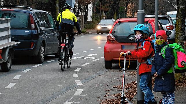 Die Schülerinnen Emelie und Emma wollen die Höristraße überqueren. Vorbeikommende Autos und Fahrradfahrer erschweren das Vorhaben ...