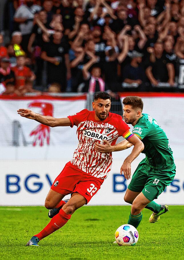 Der Freiburger Vincenzo Grifo (l) im Zweikampf mit dem Augsburger Elvis Rexhbecaj.