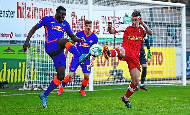Baptiste Santamaria (r) im Kampf um den Ball mit Leipzigs Abwehrspieler Dayot Upamecano (l)
