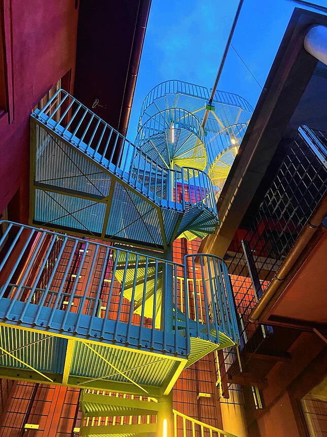 Nachts ist die moderne Wendeltreppe im grünen Innenhof (Kaiserstraße 31 / Rheinstraße 6) beleuchtet. Der Hof ist vertikal über ...