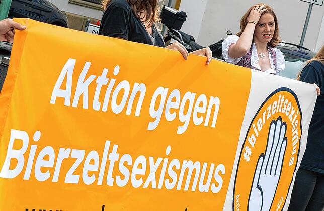 Studentin Corinna Schütz steht neben einem Banner mit der Aufschrift „Aktion gegen Bierzeltsexismus“. Die ...