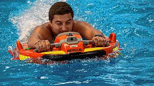 Rettungssanitäter Olivier Wiesner zeigt, wie ein aus dem Wasser zu rettender Mensch von „Dolphin 3“ in Sicherheit gebracht wird.