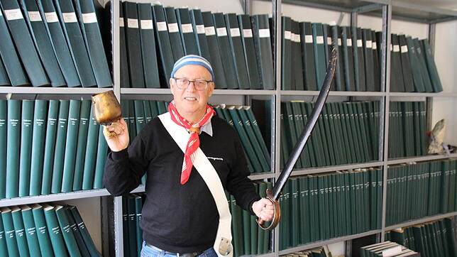 Mit Säbel und Glocke: Hubert „Hubsi“ Reiser vor den Archivbänden des SÜDKURIER in der Stockacher Lokalredaktion. Der ...