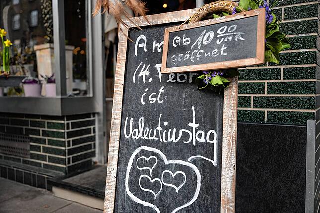Ein Schild mit der Aufschrift „Am 14. Februar ist Valentinstag“ steht vor einem Blumengeschäft. Anders als im vergangenen Jahr haben ...