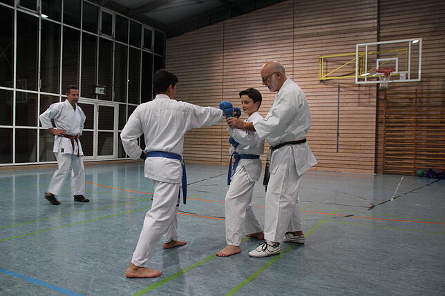 (von rechts:) Dojo-Leiter Dietmar Ehrlich zeigt den Karate-Schülern Jakob Pfaff und Samuel Gaviria, wie sie einen Schlag richtig ...