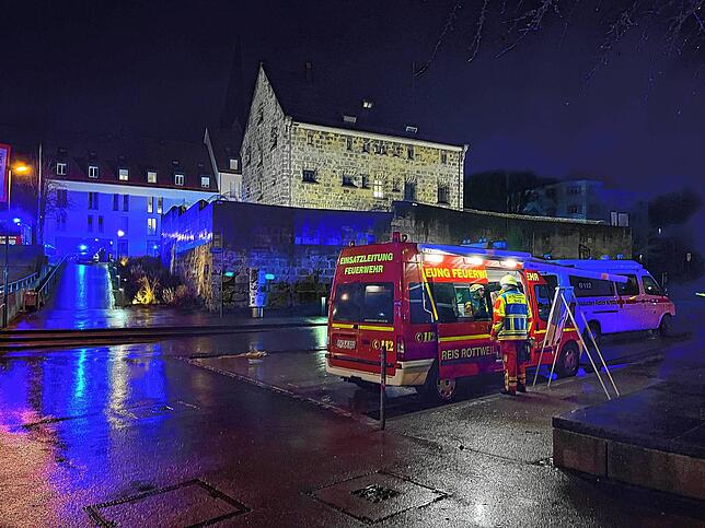 Die Feuerwehr hat sich auch großen Parkplatz am Nägelesgraben postiert, im Hintergrund ist der angeleuchtete Bau der Haftanstalt zu sehen.