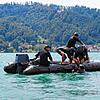 Vier Soldaten befinden sich im Wasser und müssen in der Übung gerettet werden. Sie helfen sich auch gegenseitig ins Boot.