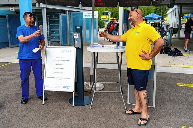 Stammgast Wolfgang Nichtern präsentiert Schwimmeister Jerome Jover am Eingang seinen Impfpass. Da er bereits vor zwei Wochen seine ...