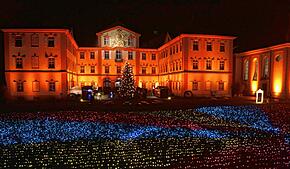 (Archivbild von 2024) Das Barockschloss ist im vergangenen Jahr in wechselndes Licht getaucht. Davor flimmert ein Lichtermeer mit dem ...