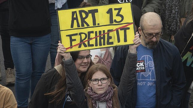 Ein Plakat mit der Aufschrift "Art. 13" und dem durchgestrichenen Wort "Freiheit" zeigt eine junge Frau bei der Demonstration gegen die ...
