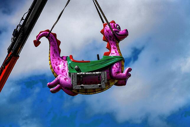 Da schwebt er ein, der kleine rosafarbene Drache für das Kinderkarussell und er zumindest lächelt, egal wie das Wetter ist.