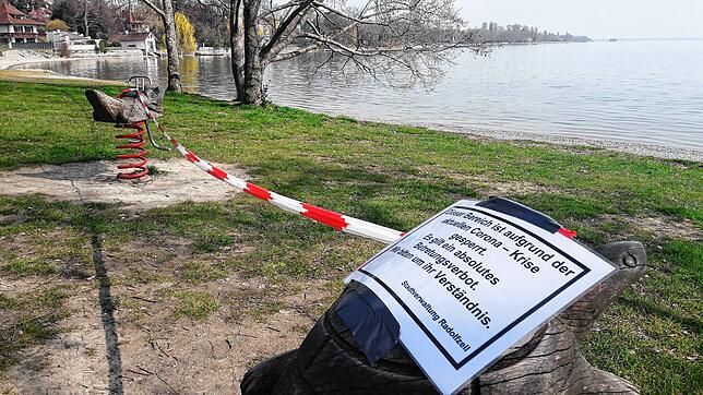 Bitte nicht wippen: Absperrband und Schild am Seeufer weisen darauf hin &ndash; das Spielgerät darf nicht benutzt werden.