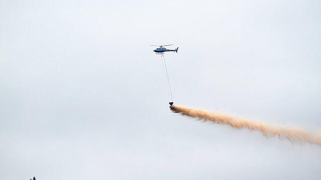Ein Hubschrauber wirft Kalk über einem Wald ab. Dies soll Folgen des sauren Regens mildern. Foto: Hans-Jörg Hellwig/stock.adobe