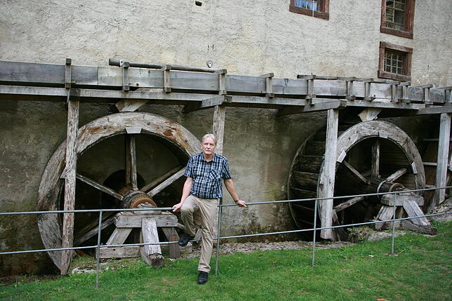 Ortsvorsteher Gerd Müller vor den Rädern der Museumsmühle.