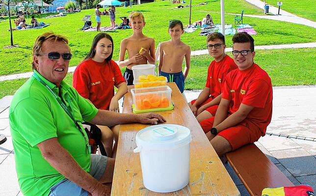 Schwimmmeister Siegfried Winter (von links, sitzend) und die jungen DLRG-Mitglieder Alina, Sebastian und Yannik verteilen ...