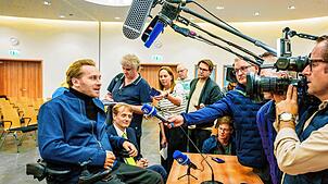 Samuel Koch (l) äußert sich nach der Urteilsverkündung am Bundessozialgericht gegenüber den Journalisten, neben ihm sitzt sein Anwalt ...