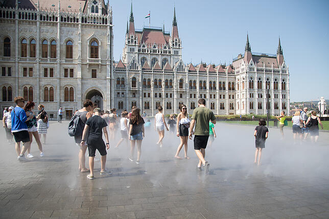 Menschen kühlen sich vor dem Parlamentsgebäude in der Innenstadt von Budapest im Sprühnebel ab.