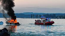 Das Motorboot steht am Samstagabend auf dem Überlinger See vor Unteruhldingen in Vollbrand. Rechts ist ein Feuerlöschboot zu sehen.