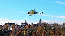 Vor der Silhoutte des historischen Innenstadt von Rottweil kommt der Helikopter herangeflogen. Er transportiert wichtige Bauteile für ...