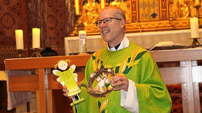 Gerührt nimmt Pfarrer Fabian Schneider Geschenke entgegen. Foto: Martha Weishaar