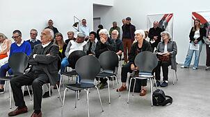Etliche Personen verfolgen in Thalheim die Laudatio von Werner Meyer, dem ehemaligen Leiter der Kunsthalle Göppingen. Ganz vorne sitzt ...