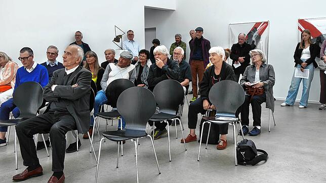 Etliche Personen verfolgen in Thalheim die Laudatio von Werner Meyer, dem ehemaligen Leiter der Kunsthalle Göppingen. Ganz vorne sitzt ...